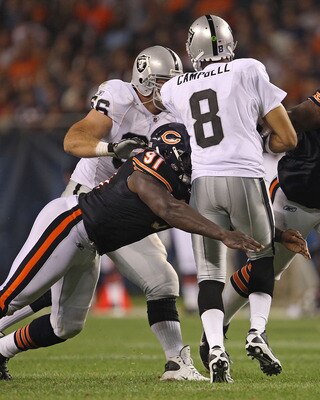 CHICAGO - AUGUST 21: Tommie Harris #91 of the Chicago Bears hits Jason Campbell #8 of the Oakland Raiders during a preseason game at Soldier Field on August 21, 2010 in Chicago, Illinois. The Raiders defeated the Bears 32-17. (Photo by Jonathan Daniel/Get