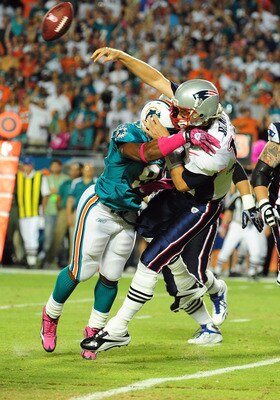 MIAMI - OCTOBER 4: Tom Brady #12 of the New England Patriots is hit as he passes by Cameron Wake #91 of the Miami Dolphins at Sun Life Field on October 4, 2010 in Miami, Florida. (Photo by Scott Cunningham/Getty Images)