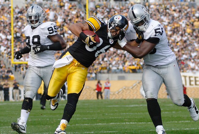 PITTSBURGH - NOVEMBER 21:  Hines Ward #86 of the Pittsburgh Steelers attempts to stiff arm Rolando McClain #55 of the Oakland Raiders after a catch during the game on November 21, 2010 at Heinz Field in Pittsburgh, Pennsylvania.  (Photo by Jared Wickerham