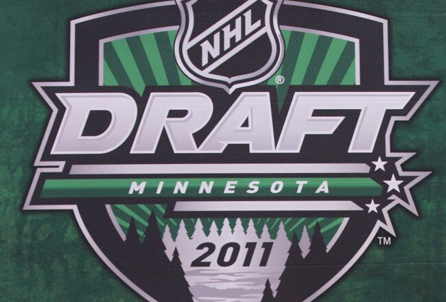 ST PAUL, MN - JUNE 24:  Eighteenth overall pick Mark McNeill by the Chicago Blackhawks stands onstage for a photo with General Manager Stan Bowman and members of the Chicago Blackhawks organization during day one of the 2011 NHL Entry Draft at Xcel Energy
