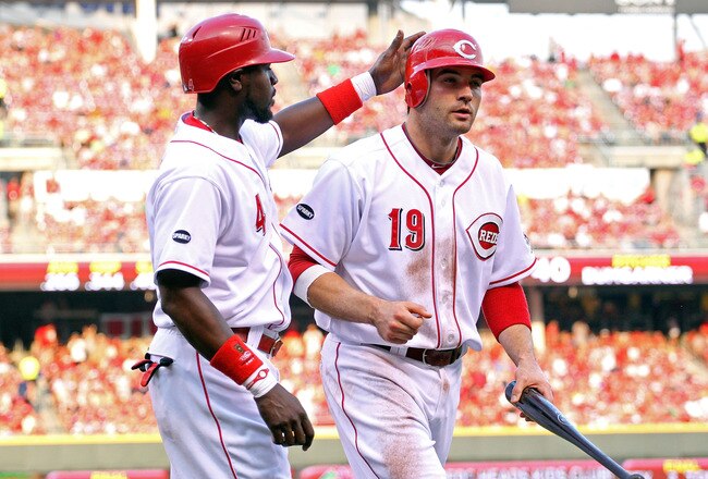 CINCINNATI, OH - JULY 30:  Joey Votto #19 of the Cincinnati Reds is congratulated by Brandon Phillips #4 after they both scored during the game against the San Francisco Giants at Great American Ball Park on July 30, 2011 in Cincinnati, Ohio.  (Photo by A