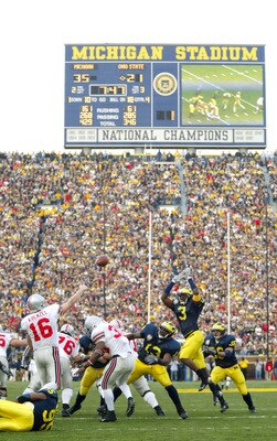 ANN ARBOR, MI - NOVEMBER 22:  Quarterback Craig Krenzel #16 of the Ohio State Buckeyes throws a pass as Alain Kashama #95 of the Michigan Wolverines holds onto him and Marlin Jackson #3 of Michigan jumps in attempt to bat the pass down in front of a recor