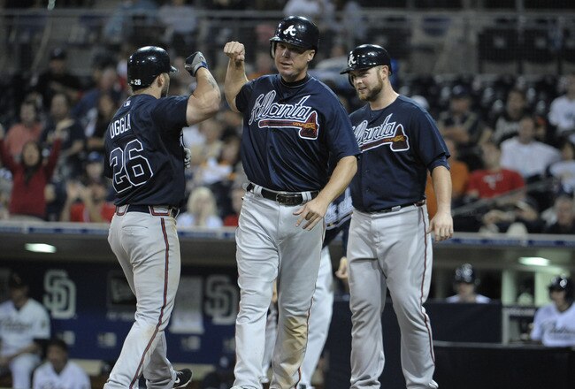 SAN DIEGO, CA - JUNE 25: Dan Uggla #26 of the Atlanta Braves is congratulated by Chipper Jones #10, center, and Brian McCann #16, right, after Uggla hit a three-run homer during the ninth inning of a baseball game against the San Diego Padres at Petco Par