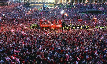 LIVERPOOL, ENGLAND - MAY 26:  The Liverpool team ride on an open top bus through a mass of fans as they arrive at St. George's Hall during the Liverpool Champions League Victory Parade on May 26, 2005 in Liverpool, England. Over 250,000 cheering fans have