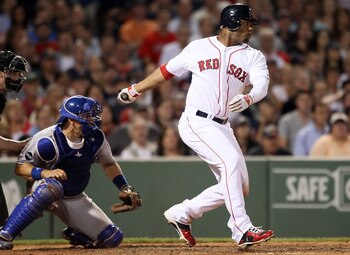 BOSTON, MA - JULY 26:  Carl Crawford #13 of the Boston Red Sox hits an RBI single as Matt Treanor #15 of the Kansas City Royals catches in the fifth inning on July 26, 2011 at Fenway Park in Boston, Massachusetts.  (Photo by Elsa/Getty Images)