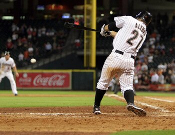 HOUSTON - AUGUST 01:  Jose Altuve #27 of the Houston Astros drives the ball up the middle for a fielders choice in the 10th inning scoring Humberto Quintero #51 from third base after the throw to home could not be handled by catcher Ryan Hanigan #29 at Mi
