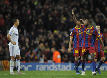 BARCELONA, SPAIN - NOVEMBER 29: Cristiano Ronaldo of Real Madrid (L) looks on as Eric Abidal (2ndR) of Barcelona gestures after Barcelona scored five goals againts Real Madrid, during the La Liga match between Barcelona and Real Madrid at the Camp Nou S