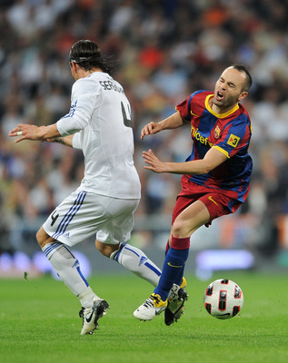 MADRID, SPAIN - APRIL 16: Andres Iniesta (R) of Barcelona is fouled by Sergio Ramos of Real Madrid during the la Liga match between Real Madrid and Barcelona at Estadio Santiago Bernabeu on April 16, 2011 in Madrid, Spain. (Photo by Jasper Juinen/Getty