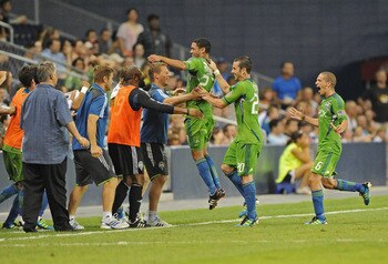 KANSAS CITY, KS - AUGUST 06:  Mid fielder Lamar Neagle #27 of the Seattle Sounders FC runs to the bench and celebrates with his teammates after scoring the go ahead goal in extra time against  Sporting Kansas City on August 6, 2011 at LiveStrong Sporting