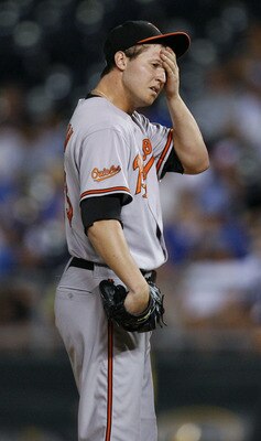 KANSAS CITY, MO - AUGUST 04: Zach Britton #53 starting pitcher of the Baltimore Orioles wipes his face after giving up a single to Alex Gordon #4 of the Kansas City Royals in the sixth inning at Kauffman Stadium on August 4, 2011 in Kansas City, Missouri.