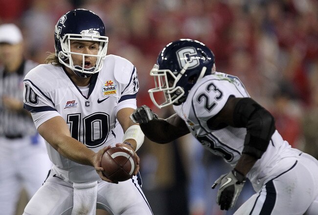 GLENDALE, AZ - JANUARY 01:  Zach Frazer #10 of the Connecticut Huskies  hands the ball off to Jordan Todman #23 against the Oklahoma Sooners during the Tostitos Fiesta Bowl at the Universtity of Phoenix Stadium on January 1, 2011 in Glendale, Arizona.  (P