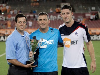 HOUSTON - JULY 20:  (L-R) Houston Dynamo President Chris Canetti presents the Charities Cup to Owen Coyle and Gary Cahill, head coach and captain of the Bolton Wanderers, after they defeated the Houston Dynamo 2-0 at Robertson Stadium on July 20, 2011 in