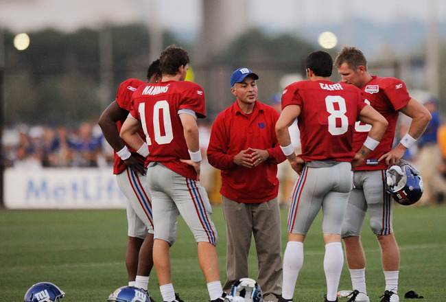 EAST RUTHERFORD, NJ - AUGUST 08:  Quarterback coach Mike Sullivan of the New York Giants speaks Eli Manning #10, David Carr #8, Ryan Perrilloux #5, and Sage Rosenfels #18 take part in practice at New Meadowlands Sports Complex on August 8, 2011 in East Ru
