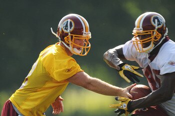 ASHBURN, VA - JULY 29:  John Beck #3 of the Washington Redskins hands off the ball to Ryan Torain #46 during the first day of training camp at Redskins Park on July 29, 2011 in Ashburn, Virginia.  (Photo by Mitchell Layton/Getty Images)