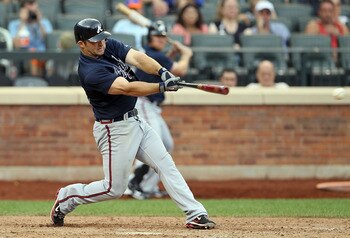 NEW YORK, NY - AUGUST 07:  Dan Uggla #26 of the Atlanta Braves connects on a eighth inning single against the New York Mets at Citi Field on August 7, 2011 in the Flushing neighborhood of the Queens borough of New York City. The Braves defeated the Mets 6