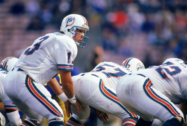 ANAHEIM, CA - 1986:  Quarterback Dan Marino #13 of the Miami Dolphins prepares for the snap at the line of scrimmage during a game against the Los Angeles Rams in 1986 at Anaheim Stadium.  (Photo by Mike Powell/Getty Images)
