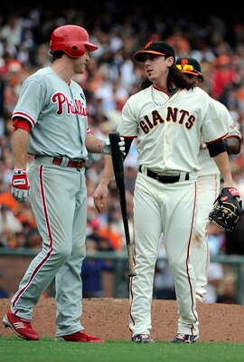 SAN FRANCISCO, CA - AUGUST 7: Tim Lincecum #55 of the San Francisco Giants, hit with the bat thrown by Chase Utley of the Philadelphia Phillies, hands it back to him in the eighth inning during an MLB baseball game at AT&T Park August 7, 2011 in San Franc