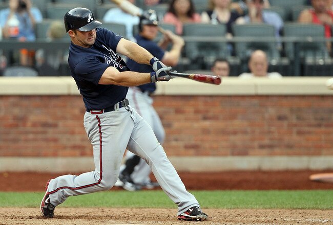 NEW YORK, NY - AUGUST 07:  Dan Uggla #26 of the Atlanta Braves connects on a eighth inning single against the New York Mets at Citi Field on August 7, 2011 in the Flushing neighborhood of the Queens borough of New York City. The Braves defeated the Mets 6