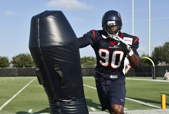 HOUSTON, TX - AUGUST 01:  Outside linebacker Mario Williams #90 of the Houston Texans hits the tackling dummy during practice on the first day of training camp at Reliant Park on August 1, 2011 in Houston, Texas.  (Photo by Bob Levey/Getty Images)