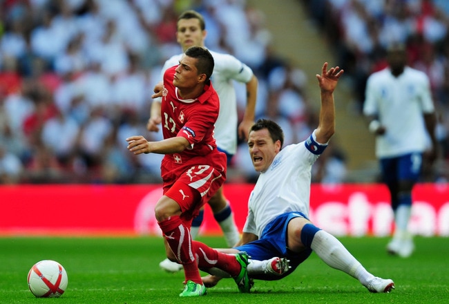 LONDON, ENGLAND - JUNE 04:  John Terry of England (R) tackles Granit Xhaka of Switzerland during the UEFA EURO 2012 group G qualifying match between England and Switzerland at Wembley Stadium on June 4, 2011 in London, England.  (Photo by Jamie McDonald/G