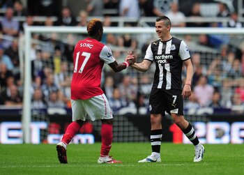 NEWCASTLE UPON TYNE, ENGLAND - AUGUST 13:  Joey Barton of Newcastle shakes hands with Alex Song of Arsenal during the Barclays Premier League match between Newcastle United and Arsenal at St James' Park on August 13, 2011 in Newcastle upon Tyne, England.