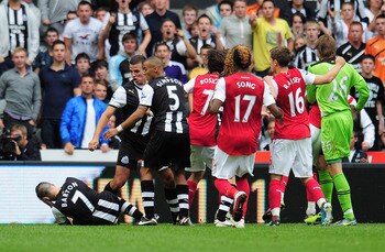 NEWCASTLE UPON TYNE, ENGLAND - AUGUST 13: Joey Barton of Newcastle goes to ground clutching his head after a clash with Gervinho of Arsenal during the Barclays Premier League match between Newcastle United and Arsenal at St James' Park on August 13, 2011