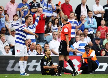 LONDON, ENGLAND - AUGUST 13:  Clint Hill (L) of Queens Park Rangers is shown the red card by referee Martin Atkinson after a challenge on Martin Petrov of Bolton during the Barclays Premier League match between Queens Park Rangers and Bolton Wanderers at