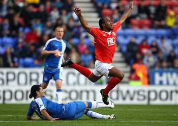 WIGAN, ENGLAND - MARCH 19:  Cameron Jerome of Birmingham is tripped by Antolin Alcaraz of Wigan during the Barclays Premier League match between Wigan Athletic and Birmingham City at the DW Stadium on March 19, 2011 in Wigan, England.  (Photo by Richard H