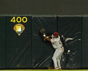 ANAHEIM, CA - JUNE 10:  Marlon Byrd #29 of the Philadelphia Phillies can't make the catch at the wall on a triple hit by Tim Salmon #15 of the Anaheim Angels in the sixth inning on June 10, 2003 at Edison Field in Anaheim, California. Salmon went on to sc