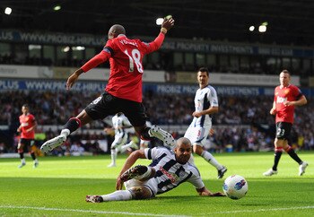 New Manchester United signing Ashley Young jumps to avoid the tackle of West Brom midfielder Steven Reid