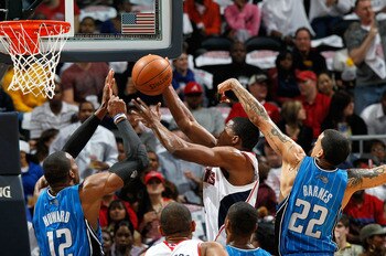 ATLANTA - MAY 10:  Joe Johnson #2 of the Atlanta Hawks drives to the basket against Dwight Howard #12 and Matt Barnes #22 of the Orlando Magic during Game Four of the Eastern Conference Semifinals of the 2010 NBA Playoffs at Philips Arena on May 10, 2010