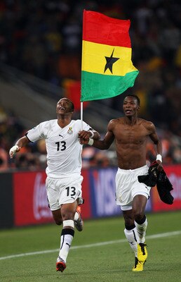 JOHANNESBURG, SOUTH AFRICA - JUNE 23: Andre Ayew (L) and John Pantsil of Ghana celebrate with a national flag having qualified for the next round, despite losing the match, during the 2010 FIFA World Cup South Africa Group D match between Ghana and German