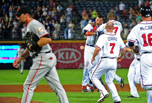 ATLANTA - AUGUST 16: Martin Prado #14 of the Atlanta Braves is mobbed by teammates after knocking in the game-winning run in the 11th inning against the San Francisco Giants at Turner Field on August 16, 2011 in Atlanta, Georgia. (Photo by Scott Cunningha