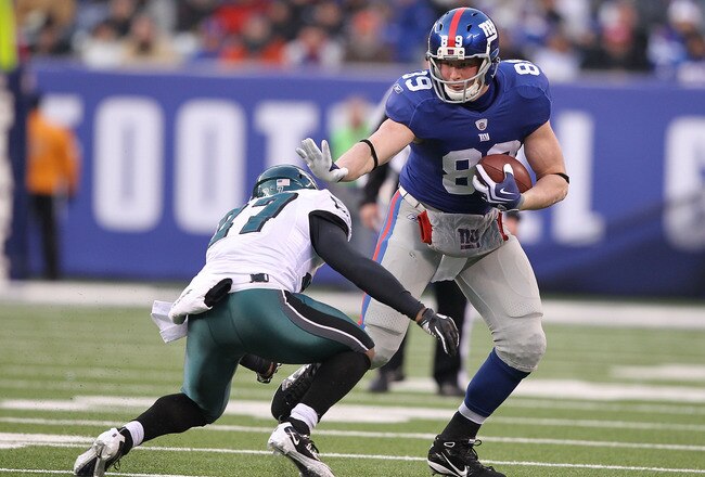 EAST RUTHERFORD, NJ - DECEMBER 19:  Kevin Boss #89 of the New York Giants stiff arms Quintin Mikell #27 of the Philadelphia Eagles during their game on December 19, 2010 at The New Meadowlands Stadium in East Rutherford, New Jersey.  (Photo by Al Bello/Ge