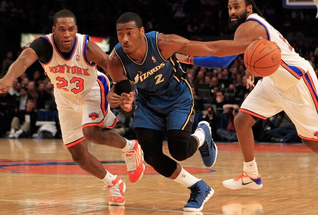 NEW YORK, NY - JANUARY 24: John Wall #2 of the Washington Wizards drives past  Toney Douglas #23 of the New York Knicks at Madison Square Garden on January 24, 2011 in New York City. NOTE TO USER: User expressly acknowledges and agrees that, by downloadin