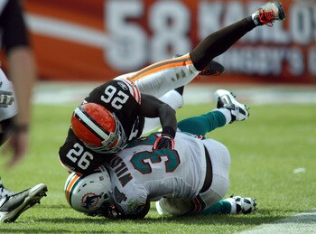MIAMI - DECEMBER 05:  Running back Ricky Williams #34 of the Miami Dolphins is brought down by Abram Elam #26 of the Cleveland Browns at Sun Life Stadium on December 5, 2010 in Miami, Florida. Cleveland defeated miami 13-10. (Photo by Marc Serota/Getty Im