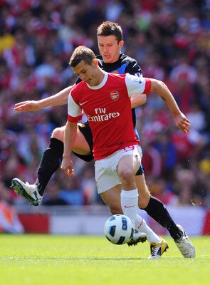 Jack Wilshere holds off the challenge of Manchester United midfielder Michael Carrick
