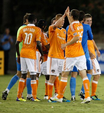 HOUSTON, TX - AUGUST 20: Cam Weaver #15 of the Houston Dynamo celebrates with teammates the Dynamo's 3-2 victory over Real Salt Lake as Andy Williams #77 of Real Salt Lake walks off the field at Robertson Stadium on August 20, 2011 in Houston, Texas.  (Ph