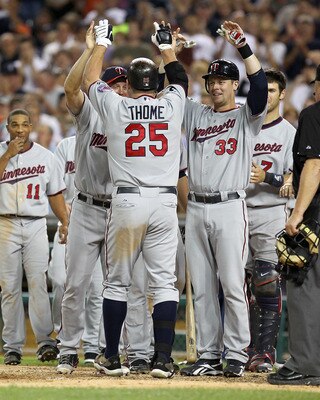 DETROIT, MI - AUGUST 15:  DH, Jim Thome #25 of the Minnesota Twins is congratulated by teammates at home plate after hitting his second home run of the game in the seventh inning and his 600th career home run making him only the eighth player in Major Lea