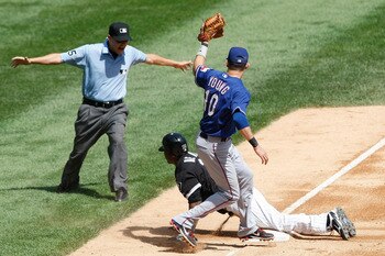 CHICAGO, IL- AUGUST  21:  Michael Young #10 of the Texas Rangers shows the the baseball to Vic Carapazza #85 after missing the tag on Alejandro De Aza #30 of the Chicago White Sox at U.S. Cellular Field on August 21, 2011 in Chicago, Illinois. (Photo by S