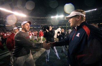 SAN DIEGO, CA - DECEMBER 30:  Head Coaches Bo Pelini (L) of the University of Nebraska Cornhuskers and Mike Stoops of the University of Arizona Wildcats shake hands after Nebraska's 33-0 victory during the Pacific Life Holiday Bowl, on December 30, 2009 a