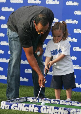 MELBOURNE, AUSTRALIA - NOVEMBER 11:  Golfer Tiger Woods (L) helps a young girl play golf during the launch of the Gillette Champions Junior Education Grant at the Crown Entertainment Complex on November 11, 2009 in Melbourne, Australia.  (Photo by Scott B