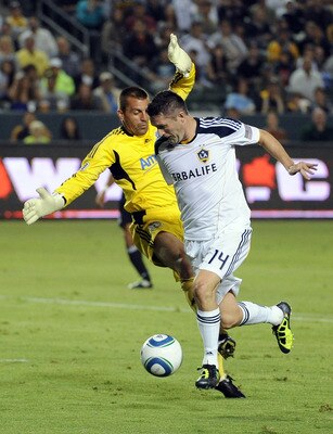 CARSON, CA - AUGUST 20:  Robbie Keane #14 of the Los Angeles Galaxy sidesteps goalkeeper Jon Busch #18 of the San Jose Earthquakes before his shot to score a goal in his debut game during the frist half at The Home Depot Center on August 20, 2011 in Carso