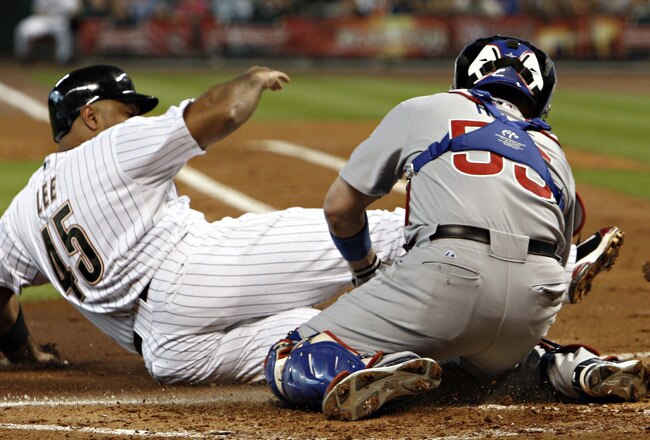 HOUSTON - AUGUST 16:  Carlos Lee #45 of the Houston Astros is tagged out at home by catcher Koyie Hill #55 trying to score in the first inning on a double by Jimmy Paredes #38 at Minute Maid Park on August 16, 2011 in Houston, Texas.  (Photo by Bob Levey/