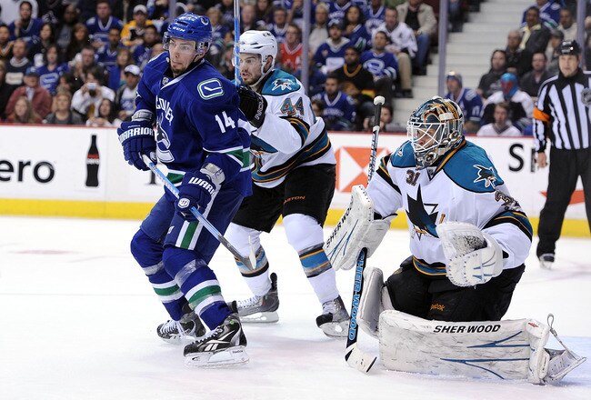 VANCOUVER, CANADA - MAY 24:  Alex Burrows #14 of the Vancouver Canucks stands in the slot area for the deflection as Marc-Edouard Vlasic #44 and goaltender Antti Niemi #31 of the San Jose Sharks defend their net in the second period in Game Five of the We