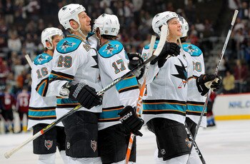 DENVER - APRIL 24:  Ryane Clowe #29, Torrey Mitchell #17 and Jamie McGinn #64 and the San Jose Sharks celebrate their victory over the Colorado Avalanche during Game Six of the Western Conference Quaterfinals of the 2010 Stanley Cup Playoffs at the Pepsi