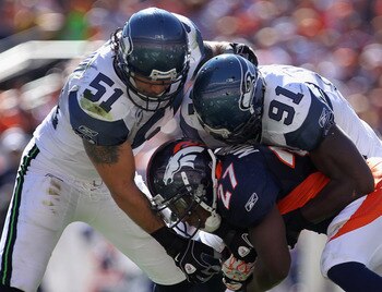 DENVER - SEPTEMBER 19:  Running back Knowshon Moreno #27 of the Denver Broncos rushes with the ball and is stopped by linebacker Lofa Tatupu #51 and defensive end Chris Clemons #91 of the Seattle Seahawks at INVESCO Field at Mile High on September 19, 201