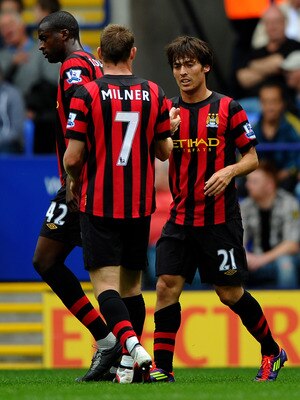 BOLTON, ENGLAND - AUGUST 21:  David Silva of Manchester City is congratulated by team mate James Milner after scoring the opening goal during the Barclays Premier League match between Bolton Wanderers and Manchester City at the Reebok Stadium on August 21