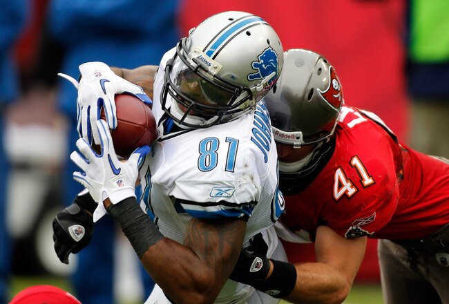 TAMPA, FL - DECEMBER 19:  Receiver Calvin Johnson #81 of the Detroit Lions stretches for additional yardage as safety Corey Lynch #41 of the Tampa Bay Buccaneers tackles him during the game at Raymond James Stadium on December 19, 2010 in Tampa, Florida.