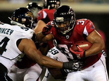 JACKSONVILLE, FL - AUGUST 19:  Jeremy Mincey #94 of the Jacksonville Jaguars attempts to tackle Michael Turner #33 of the Atlanta Falcons during a game at EverBank Field on August 19, 2011 in Jacksonville, Florida.  (Photo by Sam Greenwood/Getty Images)